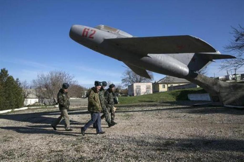 Ukrainian servicemen walk on the territory of a military unit located in the village of Lyubimovka near a local airfield southwest of Simferopol, Crimea's capital. PHOTO: REUTERS