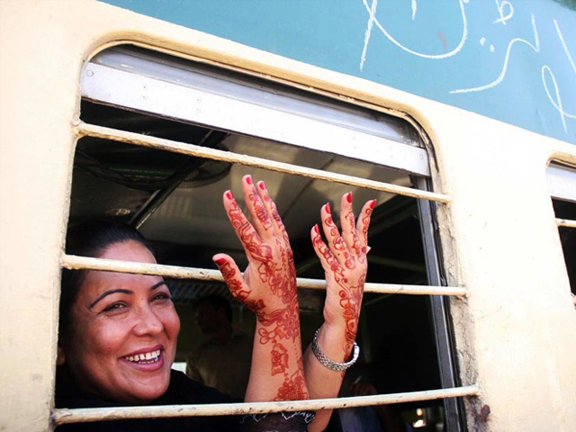 A woman showing Mehndi on her hands as she sits on first Eid Special Train leaving for Peshawar from Karachi's Cantt Railway Station in Pakistan. PHOTO: ONLINE