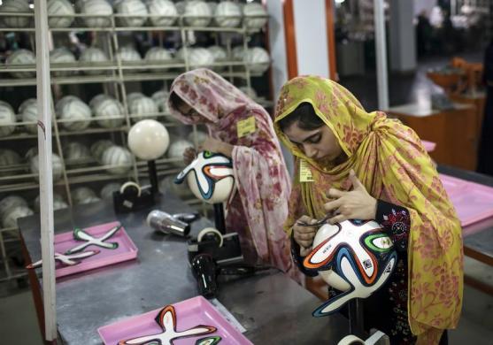 An employee adjusts outer panels on a soccer ball inside the soccer ball factory that produces official match balls for 2014 World Cup in Brazil, in Sialkot May 16, 2014. PHOTO: REUTERS