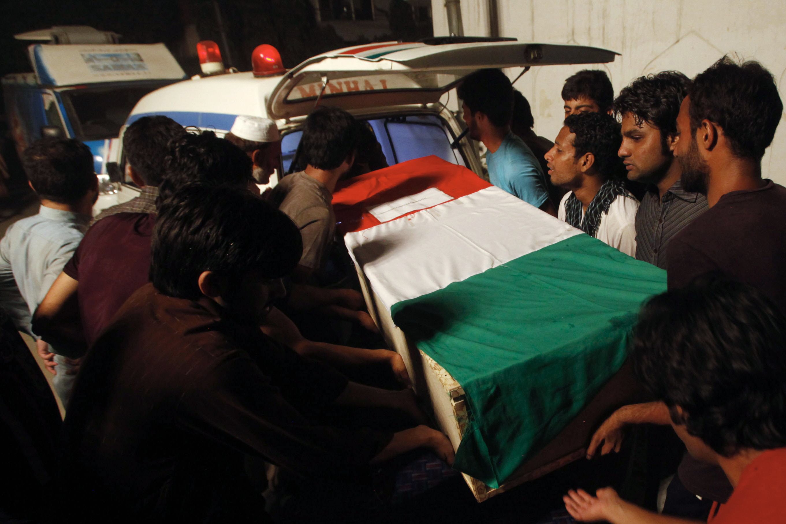 A coffin bearing a slain supporter of Tahirul-Qadri, killed during clashes with police, is shifted into an ambulance during a funeral ceremony in Lahore. PHOTO: AFP