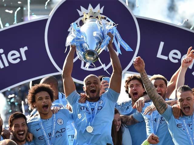 Manchester City's Belgian defender Vincent Kompany (C) holds up the Premier League trophy after their 4-1 victory in the English Premier League. PHOTO: AFP
