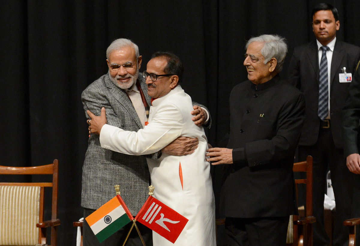 Indian Prime Minister Narinder Modi (L) and Jammu and Kashmir Deputy Chief Minister Nirmal Singh (C) embrace as Jammu and Kashmir Chief Minister Mufty Mohammed Sayeed (R) looks on during a swearing in ceremony of the state assembly in Jammu on March 1, 2015. PHOTO: AFP