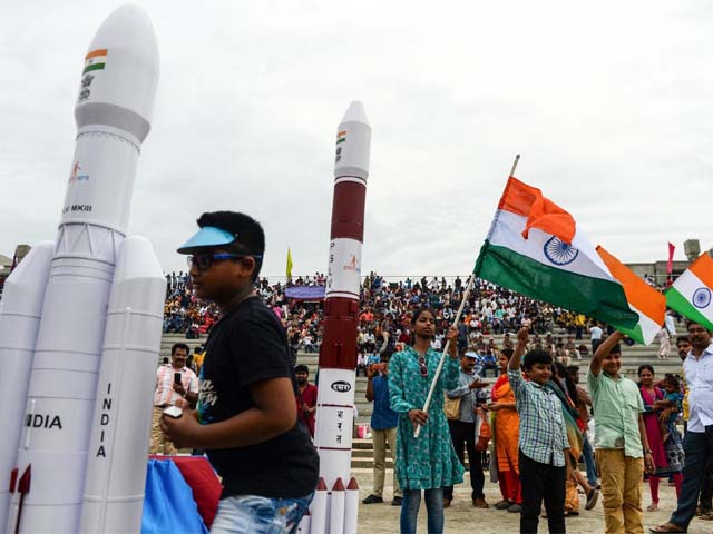 Students wave Indian national flags as the Indian Space Research Organisation (ISRO). PHOTO: AFP
