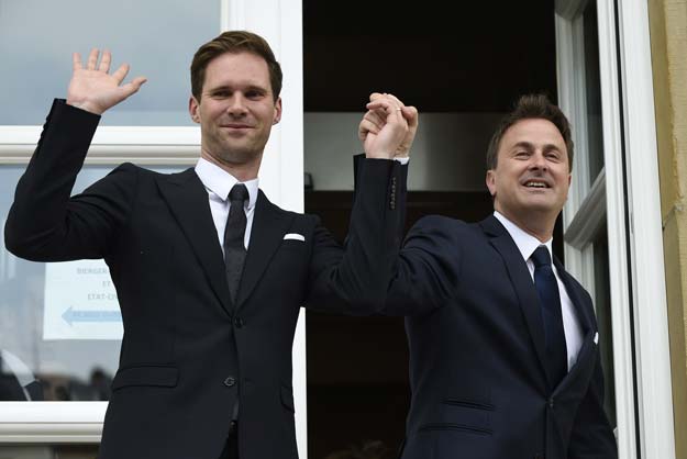 Luxembourg Prime Minister Xavier Bettel (R) holds hands with his companion Belgian architect Gauthier Destenay during their wedding in Luxembourg on May 15, 2015. PHOTO: AFP