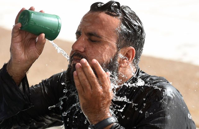 A Muslim man cools down with water at a mosque during a heatwave in Karachi on June 22, 2015. PHOTO: AFP