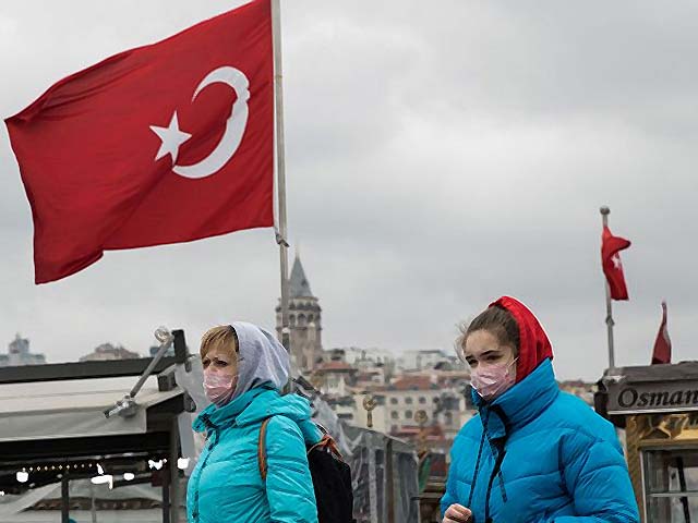 Tourists wearing protective face masks walk across Eminonu Square in Istanbul. PHOTO: GETTY