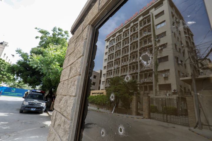 Aftermath: Bullet holes pepper the window of a security booth at the Pakistan Stock Exchange after it was attacked by terrorists on Monday, creating fear and panic in the city's financial centre. PHOTO: REUTERS